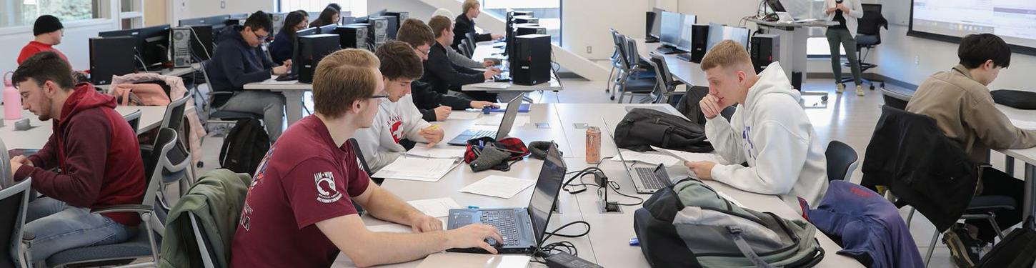 students sitting at tables in a cyber systems class